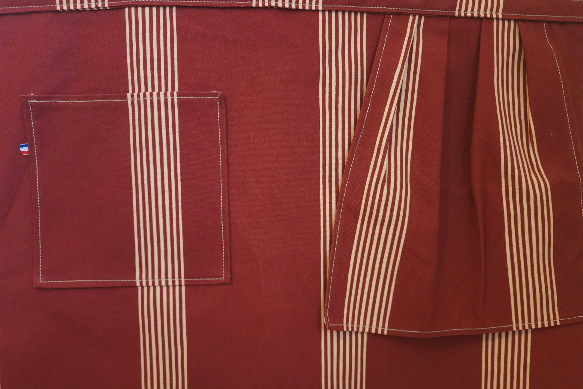 Grand tablier de cuisine avec poche et torchon intégré. couleur touge bordeaux avec rayures beige. Tablier mixte ( homme/femme). textile de aute qualité - artisanat de Haute-Loire