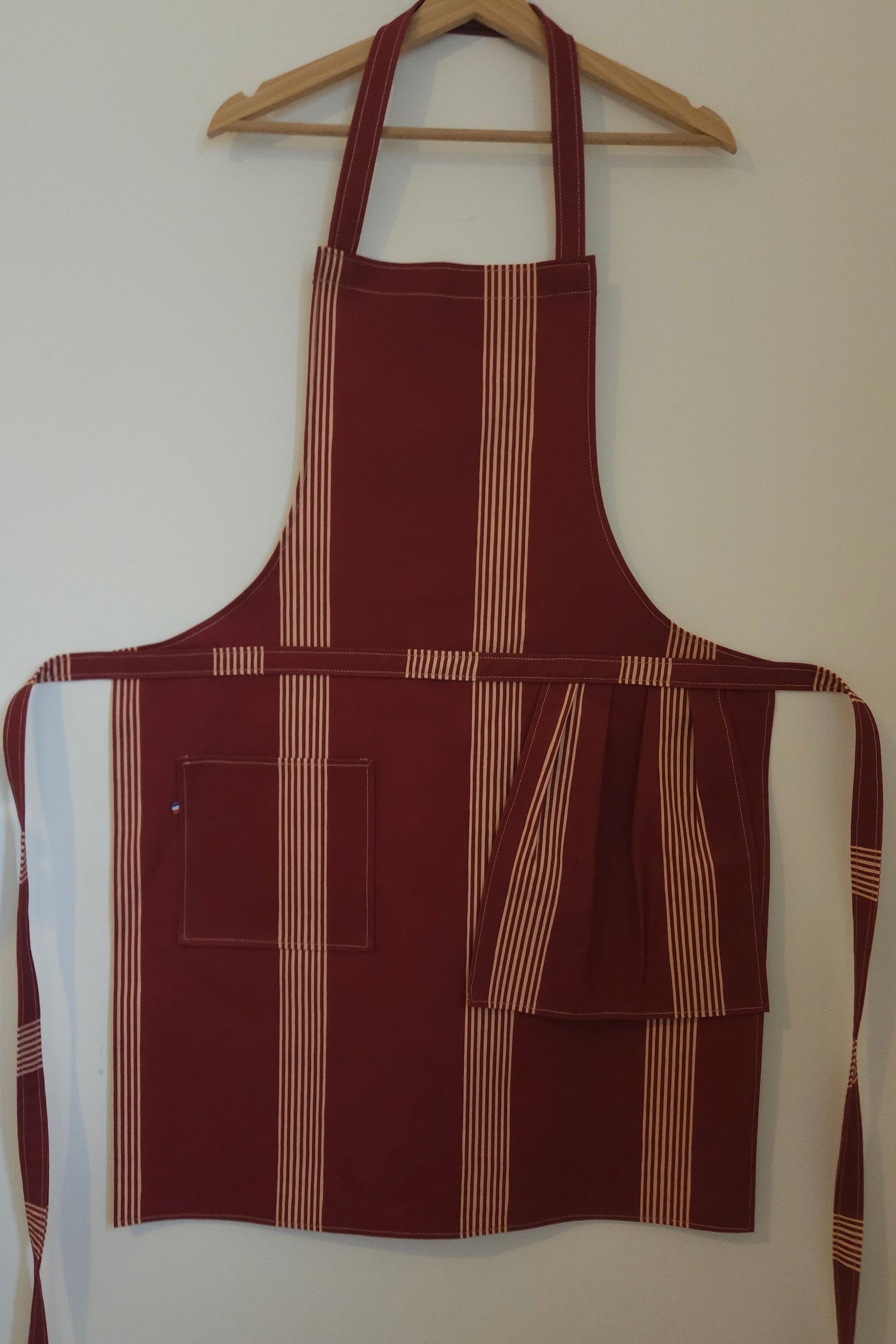Grand tablier de cuisine avec poche et torchon intégré. couleur touge bordeaux avec rayures beige. Tablier mixte ( homme/femme). textile de aute qualité - artisanat de Haute-Loire