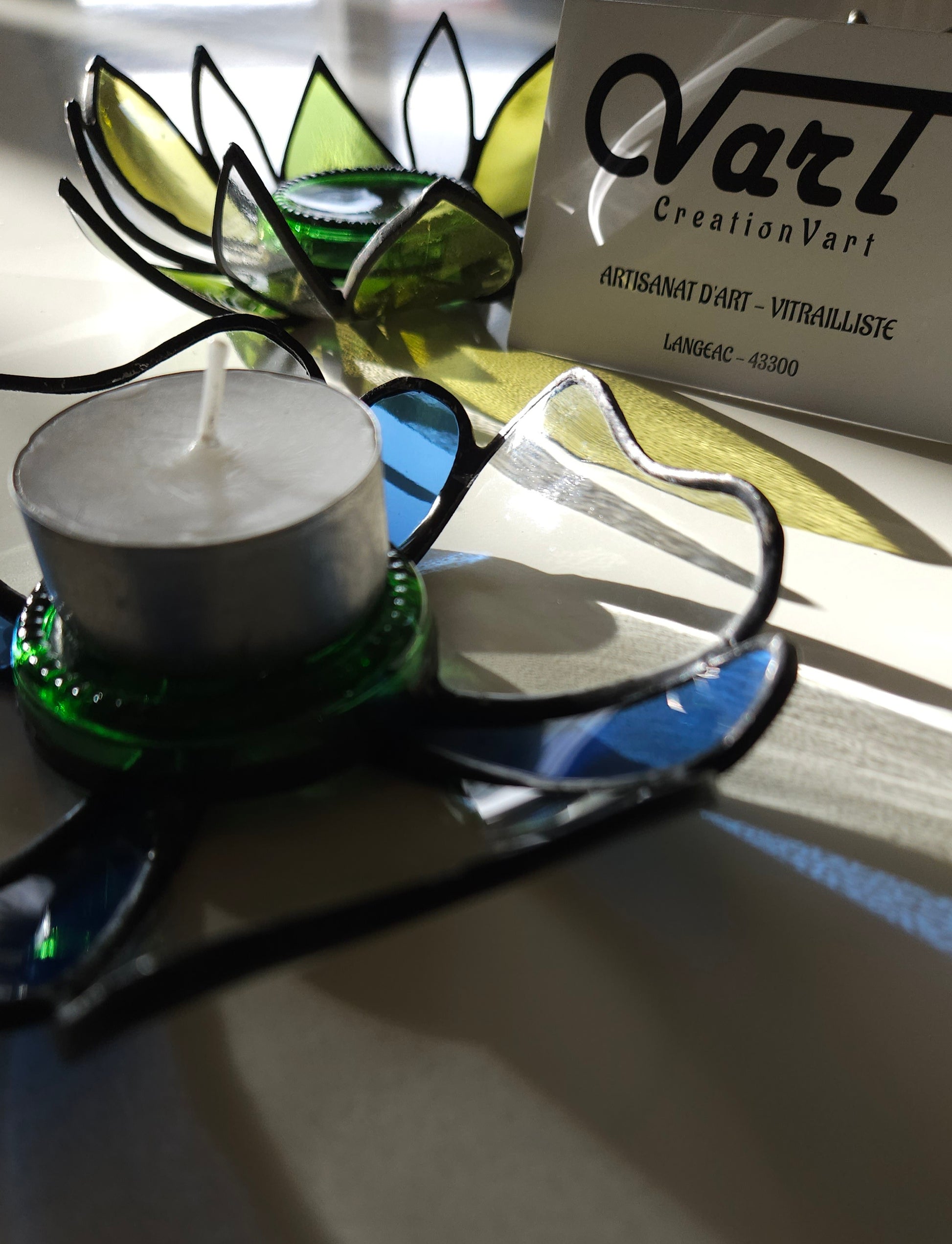 Photophore "Fleur" en verre upcyclé utilisant le savoir-faire du vitrail  Création artisanale unique réalisée par CreationVart. Artisanat de Haute-Loire. Photophore ou bougeoir en vitrail bleu et transparent sertie à l'étain.