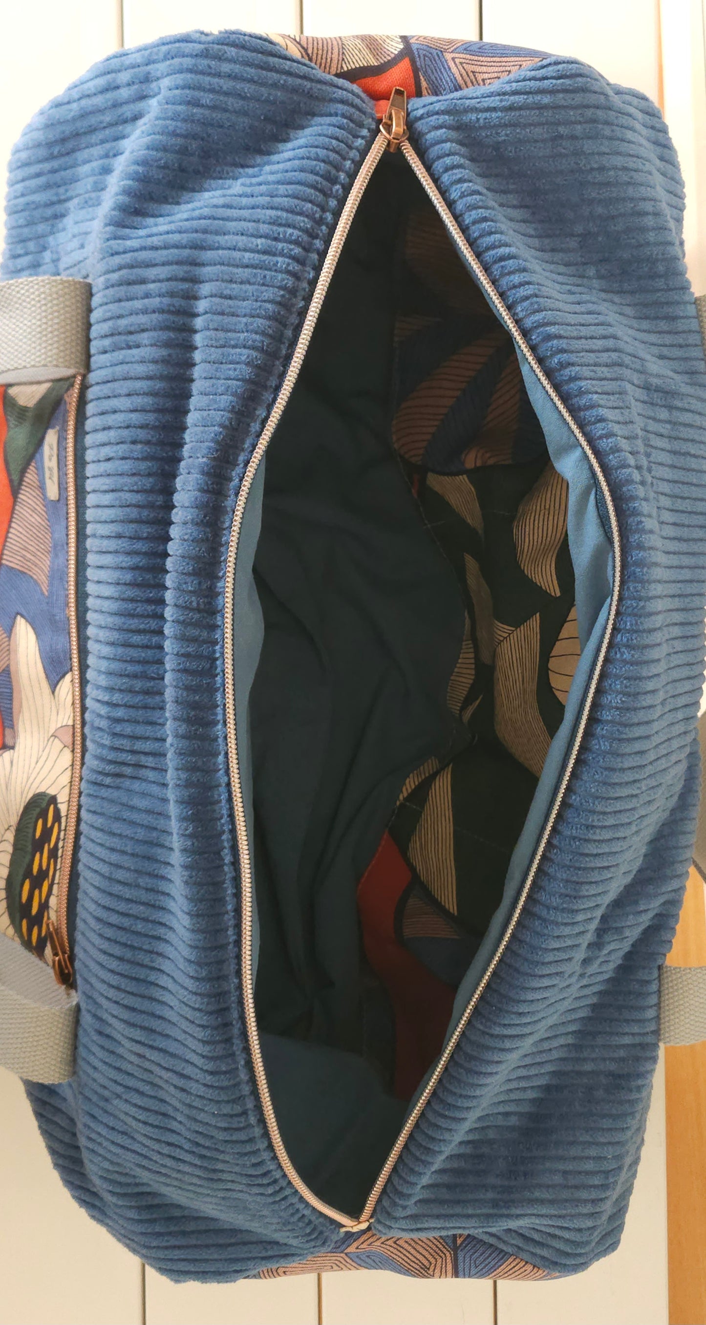 Sac polochon en velours côtelé - création artisanale unique- fait-main en Haute-Loire. Marque Po'Fil. Velours bleu et tissu motif fleuri. poignets anse de coton épais.