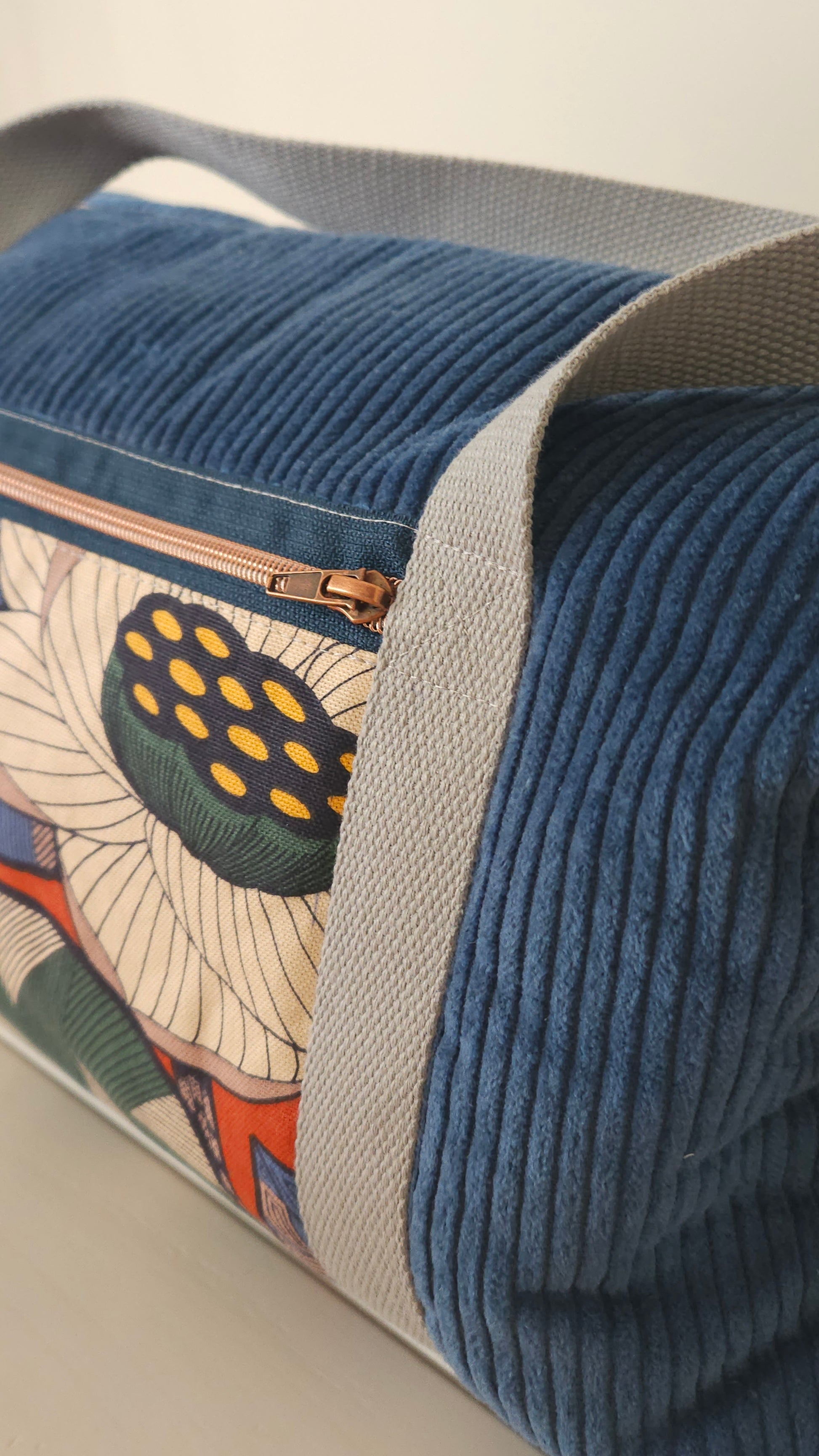 Sac polochon en velours côtelé - création artisanale unique- fait-main en Haute-Loire. Marque Po'Fil. Velours bleu et tissu motif fleuri. poignets anse de coton épais.