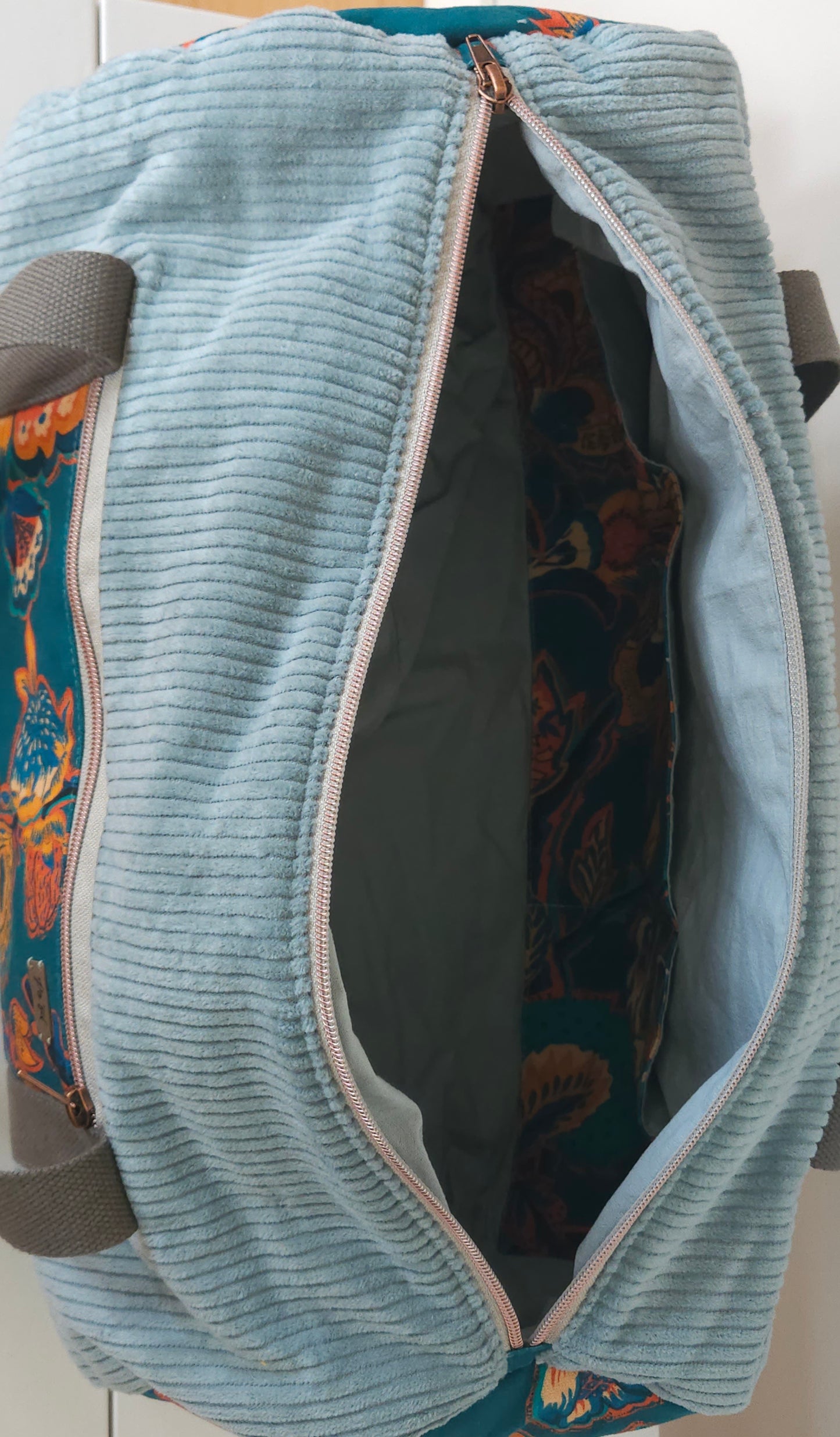 sac polochon en velours cotelé couleur vert d'eau et tissu haute qualité fleuri. fermeture zippé, poches intérieure et extérieure. création unique fabriquée en Haute-Loire (France)